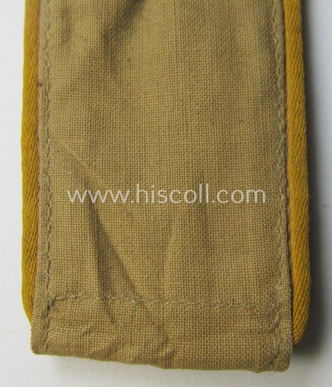 Single, WH (Luftwaffe) tropical-issued, EM-type-shoulderstrap as executed in beige-coloured linnen (as was specifically intended for usage on the tropical-shirts ie. tunics) as was intended for a: 'Soldat der Flieger- o. Fallschirmjäger-Truppen'
