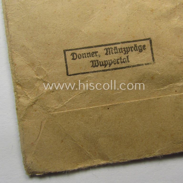 'Ehrenkreuz der deutschen Mutter - dritte Stufe' (or: bronze-class mothers'-cross) that came mounted onto its long-sized ribbon and that came stored in its period pouch by the maker: 'Donner Münzpräge - Wuppertal'