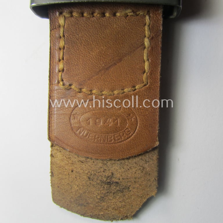 WH (Heeres) 'standard-pattern', field-grey-toned- and steel-based belt-buckle being a maker- (ie. 'H. Arld - Nuernberg'-) marked- and/or: '1941'-dated example that comes mounted onto its leather-based tab