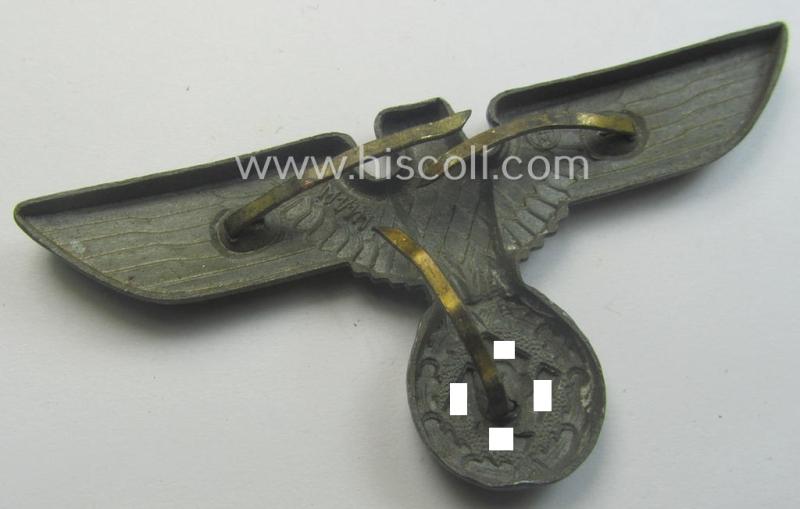 Greyish-silver-coloured- and/or: zinc- (ie. 'Feinzink'-) based (political-style) visor- (ie. 'Schirmmützen'-) cap-eagle being a detailed example that shows an: 'RzM M1/111'-makers'-designation on its back