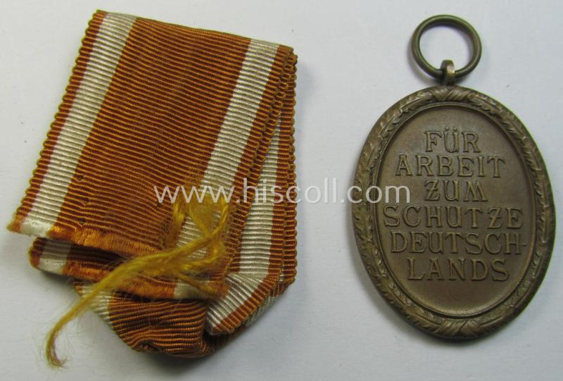 Medal-set: 'Deutsches Schutzwall Ehrenzeichen' (aka: 'Westwall'-medal) being a non-maker-marked- and/or: 'Buntmetall'-based specimen that comes together with its period- (and neatly folded ie. pre-confectioned) ribbon (ie. 'Bandabschnitt')