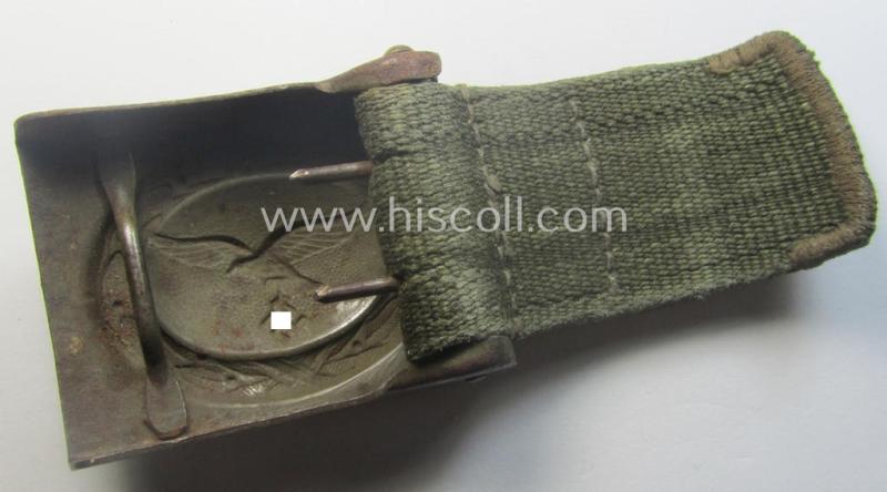 Rarely found WH (Luftwaffe) 'tropical-issued' belt-buckle being a non-maker-marked, beige-tan-coloured example that comes mounted onto its original, greenish-coloured- (and/or: 'webbing'-based-) tab