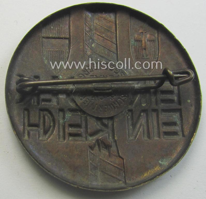 Golden-bronze-toned, N.S.D.A.P.-related day-badge (ie. 'tinnie' or: 'Veranstaltungsabzeichen') showing a broken border-pole, three provincial shields and that is entitled: 'Ein Volk - Ein Reich'