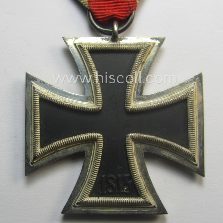 'Eisernes Kreuz II. Klasse' being a neatly maker- (ie. 'L/18'-) marked example that comes mounted onto its period- and confectioned ribbon (ie. 'Bandabschnitt') as was produced by the maker (ie. 'Hersteller'): 'B.H. Mayer's Kunstprägeanstalt'