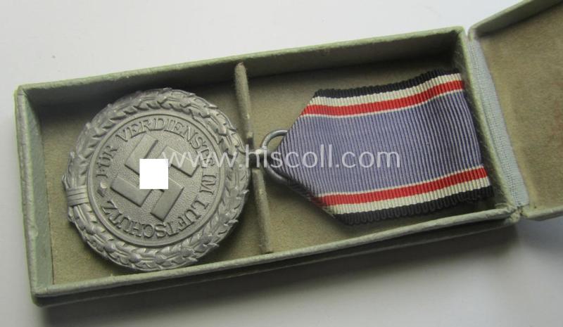 Light-weight (ie. typical aluminium-based) medal as was intended for air-raid wardens 2nd. class (or: 'Luftschutz-Ehrenzeichen 2. Stufe') that comes stored in its period, dove-grey-coloured etui
