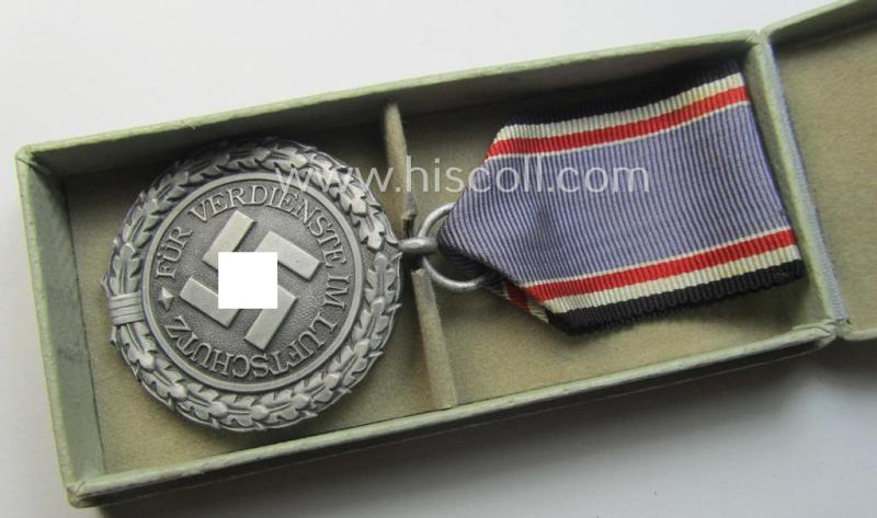 Light-weight (ie. typical aluminium-based) medal as was intended for air-raid wardens 2nd. class (or: 'Luftschutz-Ehrenzeichen 2. Stufe') that comes stored in its period, dove-grey-coloured etui