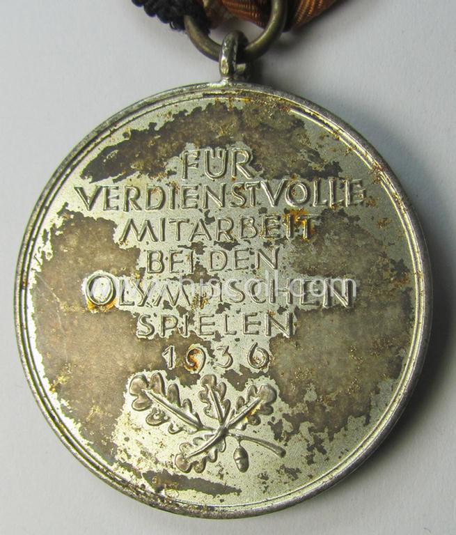 Atractive example of a: 'Deutsche Olympia-Erinnerungsmedaille 1936' being a non-maker-marked example that comes mounted onto its original (orange-red-coloured ribbon (ie. 'Bandabschnitt') as issued