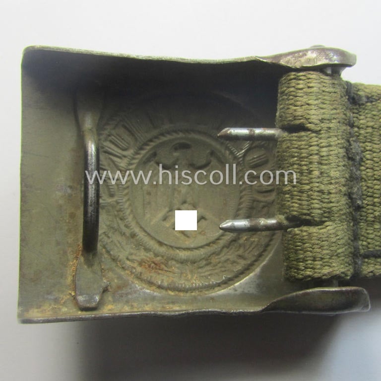 WH (Heeres) 'tropical-issued' belt-buckle being a non-maker-marked, field-grey-coloured example that comes mounted onto its original, greenish-coloured- (and/or: 'webbing'-based-) tab