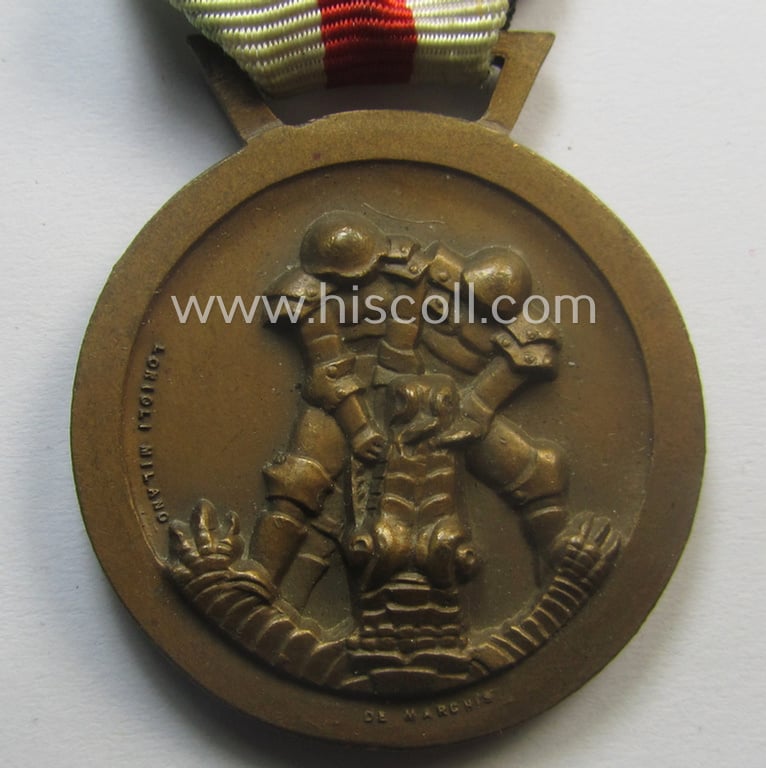 Golden-bronze-coloured- (and I deem 'Buntmetall'-based-) example of a: 'Deutsch-Italienische Feldzugsmedaille' (or: German-Italian campaign-medal) that comes mounted onto its (regular-sized) piece of original (and somewhat faded!) ribbon