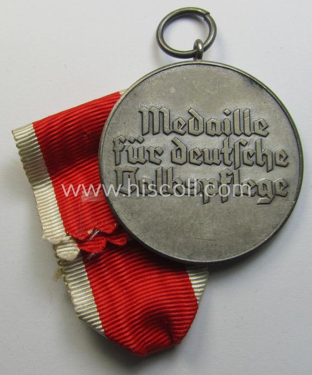 Attractive, silver-toned (and I deem zinc- ie. 'Feinzink'-based!) 'Deutsche Volkspflege'- (ie. civil-service) medal being a non-maker-marked example that came together with its (confectioned- and somewhat shortened) ribbon (ie. 'Bandabschnitt')