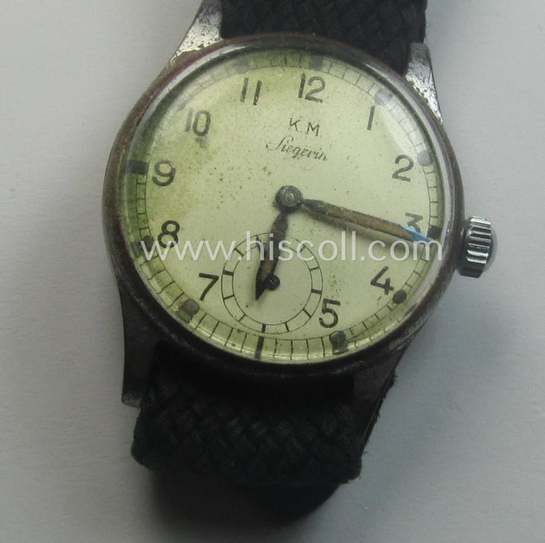 WH (Kriegsmarine) WWII-period wrist-watch (or: 'Dienstuhr') of the make: 'K.M. Siegerin' having a beige-white-coloured dial-plate and neatly engraved number on its back that reads: '109597'