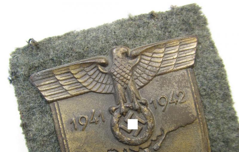 Attractive, WH (Heeres o. Waffen-SS) 'Krim'-campaign-shield that comes mounted onto its original, field-grey-coloured 'backing' and that comes in an issued-, minimally worn and/or carefully tunic-removed-, condition