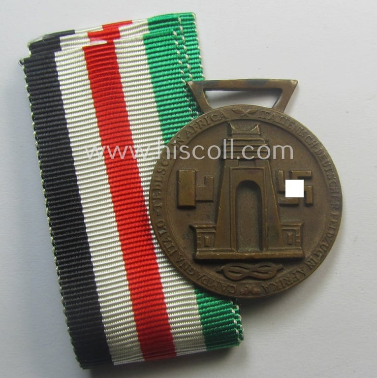 Golden-bronze-coloured (and 'Buntmetall'-based!) example of a: 'Deutsch-Italienische Feldzugsmedaille' (or: German-Italian campaign-medal) that came together with its (full length- and 'virtually mint- ie. unissued') piece of original ribbon