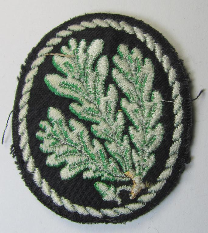 Attractive example of a WH (Heeres) so-called: 'Jäger'-armbadge, being a neatly machine-embroidered- and/or multi-coloured version as was executed on darker-green-coloured wool