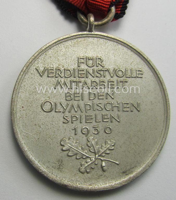 'Deutsche Olympia-Erinnerungsmedaille 1936' being a non-maker-marked example that comes mounted onto its original ribbon (ie. 'Bandabschnitt') and that comes stored in its typical, beige-white-coloured etui