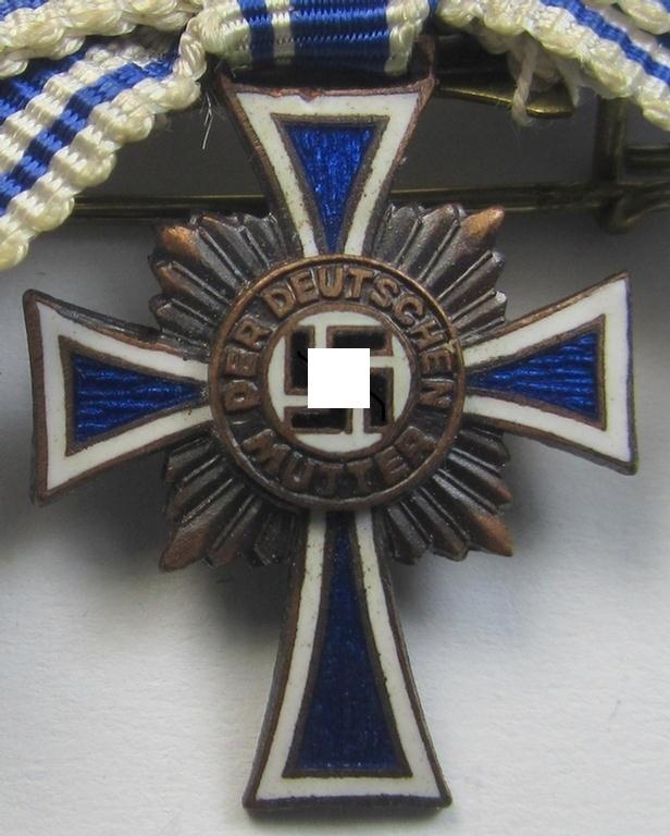 Miniature of an: 'Ehrenkreuz der deutschen Mutter - dritte Stufe' (or: bronze-class mothers'-cross) being a non-maker-marked example that comes in an overall nice- (albeit moderately worn- ie. used-), condition