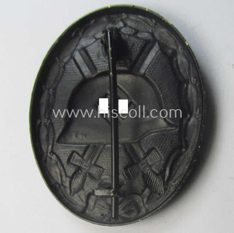 Maker- (ie. 'E.H.'-) marked example of a black-class wound-badge (or: 'Verwundeten-Abzeichen in Schwarz') being an example that was produced by the maker (ie. 'Hersteller') named: 'Eduard Hahn'