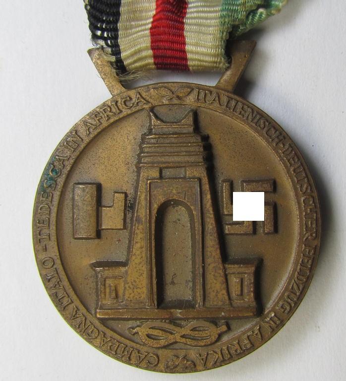 Superb, golden-bronze-coloured- (and I deem 'Buntmetall'-based-) example of a: 'Deutsch-Italienische Feldzugsmedaille' (or: German-Italian campaign medal) that comes mounted on its (regular-sized-) piece of original ribbon
