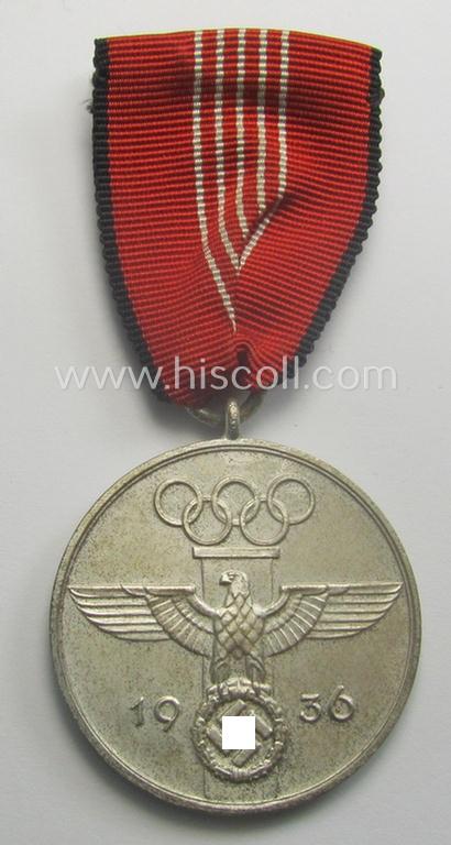 'Deutsche Olympia-Erinnerungsmedaille 1936' being a non-maker-marked example that comes mounted onto its original ribbon (ie. 'Bandabschnitt') and that comes stored in its typical, beige-white-coloured etui
