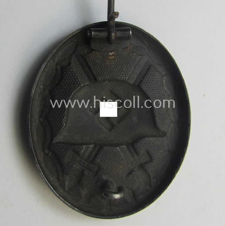 Maker- (ie. '26'-) marked example of a black-class wound-badge (or: 'Verwundeten-Abzeichen in Schwarz') being an example that was produced by the maker (ie. 'Hersteller') named: 'B.H. Mayer’s Kunstprägeanstalt - Pforzheim'