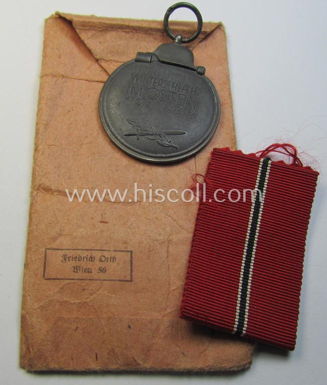 Attractive medal-set: 'Winterschlacht im Osten 1941-42' being a maker- (ie. '15'-) marked specimen by the maker- (ie. 'Hersteller') named: 'Friedrich Orth' and that comes packed in its original, 'Zellstoff'-based pouch