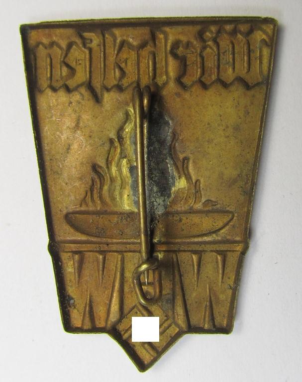 Golden-toned, W.H.W.- (ie. 'Winterhilfswerke'-) related day-badge (ie. 'tinnie') being a non-maker-marked example as was issued to commemorate a: 'WHW'-gathering ie. rally entitled: 'Wir Helfen'