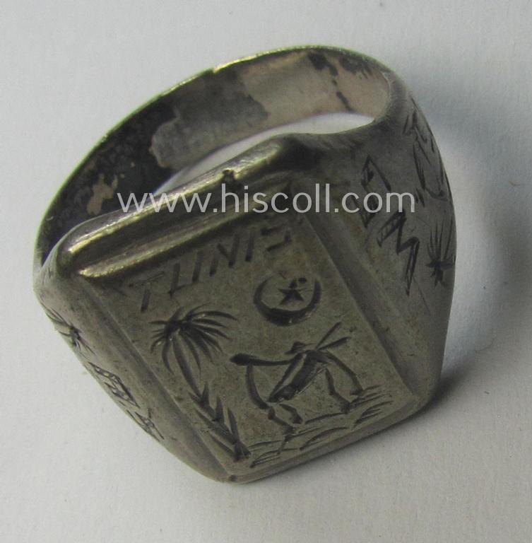 WH (LW-/Heeres- ie. 'Deutsches Afrikakorps'-) related, metal-based (ie. silver-coloured- and/or I deem genuine silver-based) so-called: 'souvenir'-ring depicting an engraved palmtree and desert scenery and showing the text: 'Tunis'