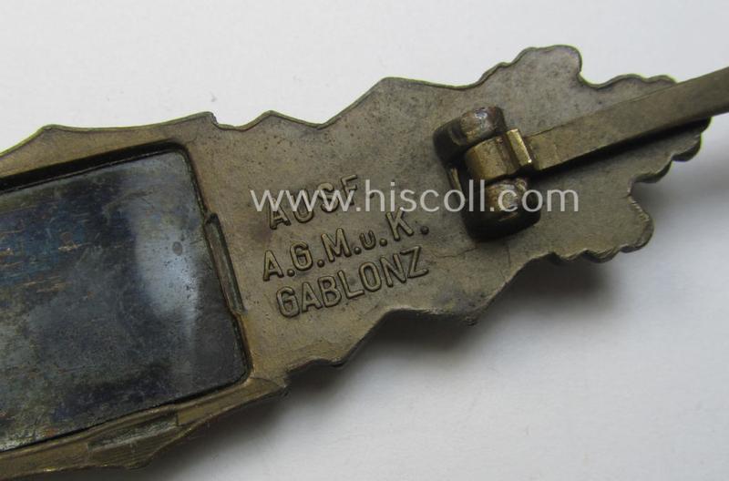 'Nahkampfspange in Bronze' (or: bronze-class close-combat clasp ie. CCC) being a maker- (ie. 'A.G.M.u.K.'-) marked- and/or minimal converse-shaped specimen having its period-attached (bluish-toned and steel-based) 'back-plate' in place