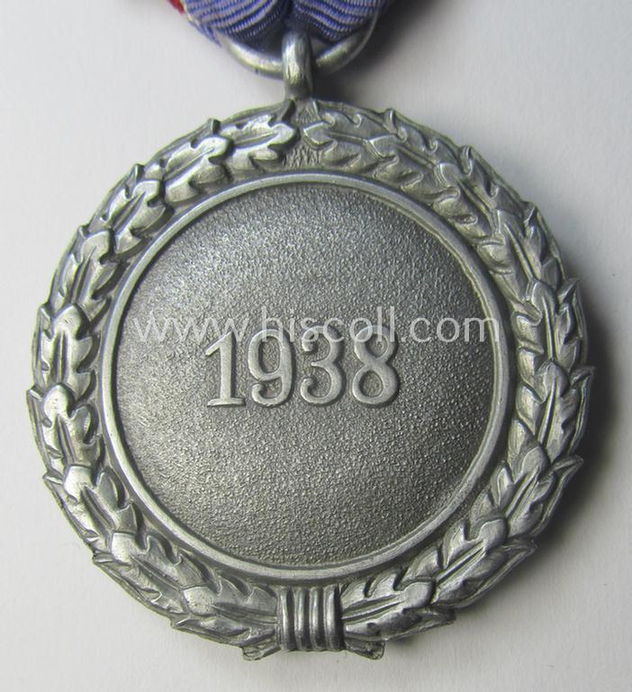 'Luftschutz-Ehrenzeichen 2. Stufe' being a maker- (ie. '10'-) marked example, as executed in (heavy) zinc-based metal (ie. 'Feinzink') and that came together with its period ribbon (ie. 'Bandabschnitt')