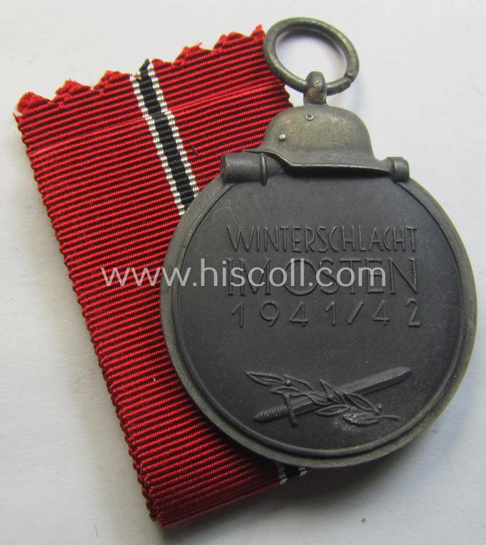 Attractive medal-set: 'Winterschlacht im Osten 1941-42' being a maker- (ie. '110'-) marked- (and/or 'Feinzink'-based) specimen by the maker: 'Otto Zappe' and that comes together with its (non-confectioned) ribbon (ie. 'Bandabschnitt')