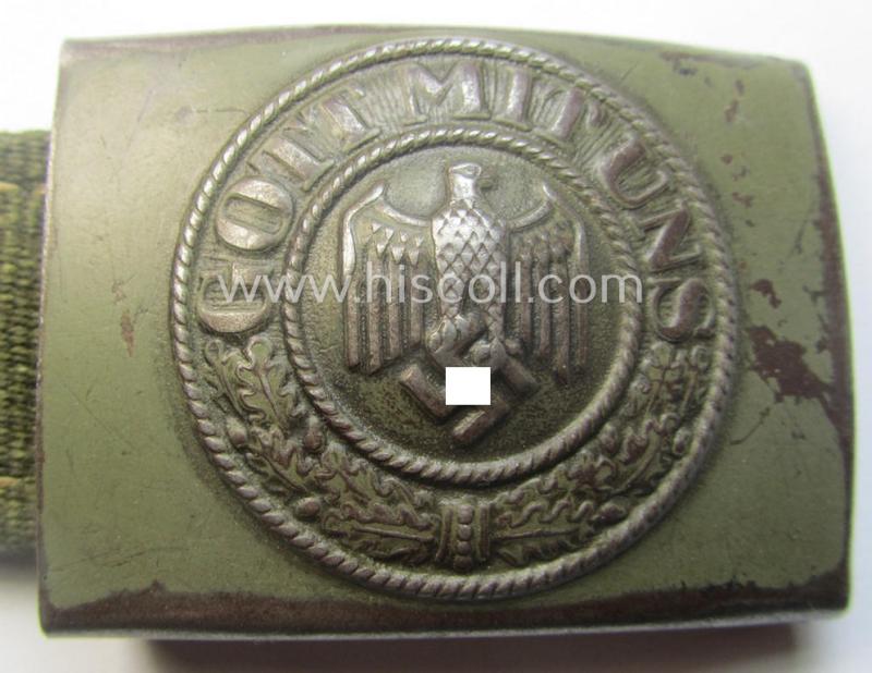WH (Heeres) 'tropical-issued' belt-buckle being a clearly maker- (ie. 'IKA 41'-) marked, field-grey-coloured example that comes mounted onto its original, greenish-coloured- (and/or: 'webbing'-based-) tab