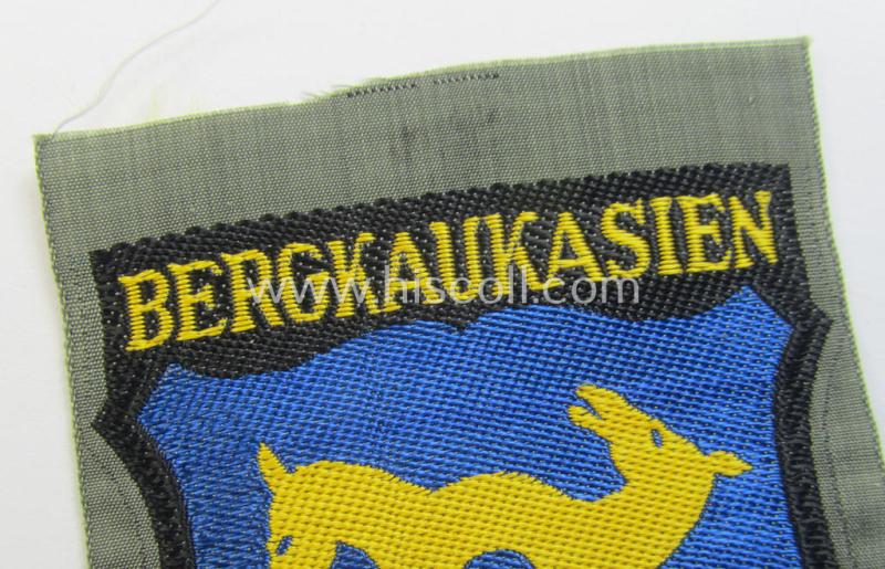 Attractive, 'BeVo'-type armshield (of the second pattern-) entitled: 'Bergkaukasien', being a piece as intended for a volunteer who served within the 'Deutsche Wehrmacht' ie. within the 'Berg- o. Nord-Kaukasisches Legion'