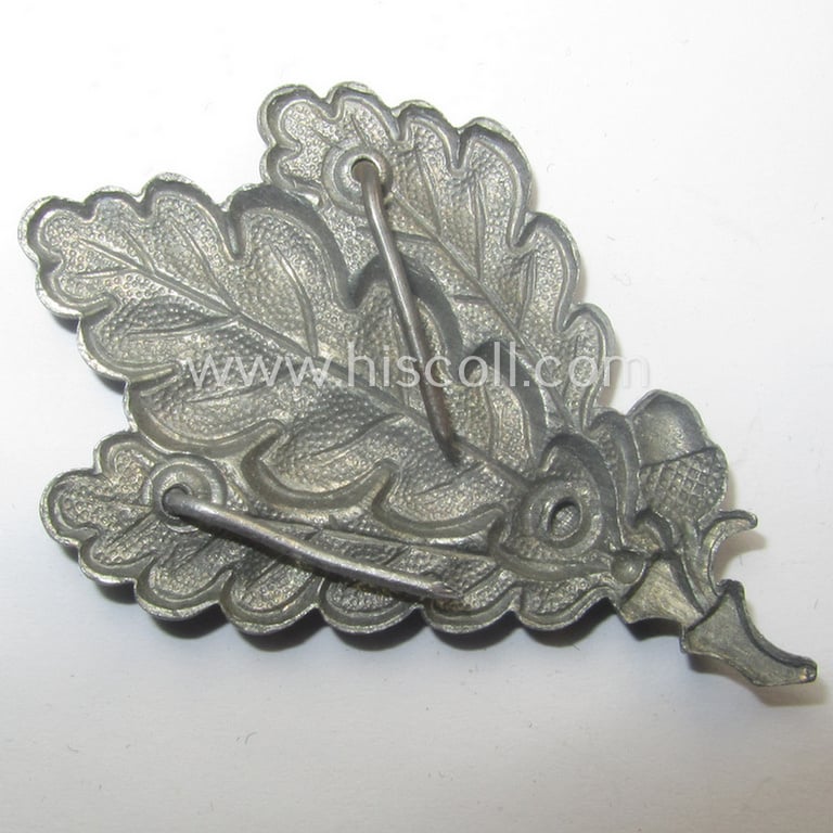WH (Heeres) greyish-silver-coloured so-called: 'M43'-pattern cap-badge (ie. 'Mützenabzeichen') depicting three: 'Eichenlaub'-branches as was used by the various 'Jäger'-related, divisional staff-members