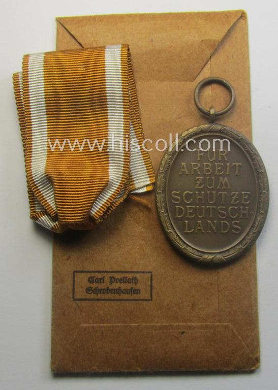 Medal-set: 'Deutsches Schutzwall Ehrenzeichen' (aka: 'Westwall'-medal) being a non-maker-marked- and/or: typical 'Buntmetall'-based specimen that comes packed in its original pouch of issue by the: 'Carl Poellath'-company