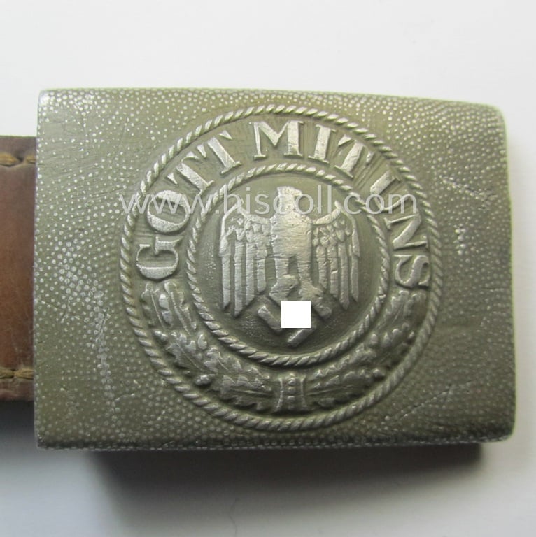 WH (Heeres) 'standard-pattern', field-grey-toned- and aluminium-based belt-buckle being a maker- (ie. 'Hermann Knoller - Pforzheim'-) marked- and/or: '1939'-dated example that comes mounted onto its leather-based tab
