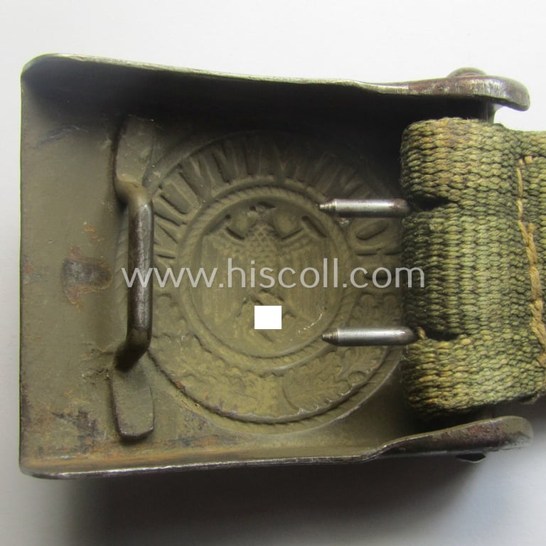 WH (Heeres) 'tropical-issued' belt-buckle being a non-maker-marked, field-grey-coloured example that comes mounted onto its original, greenish-coloured- (and/or: 'webbing'-based-) tab