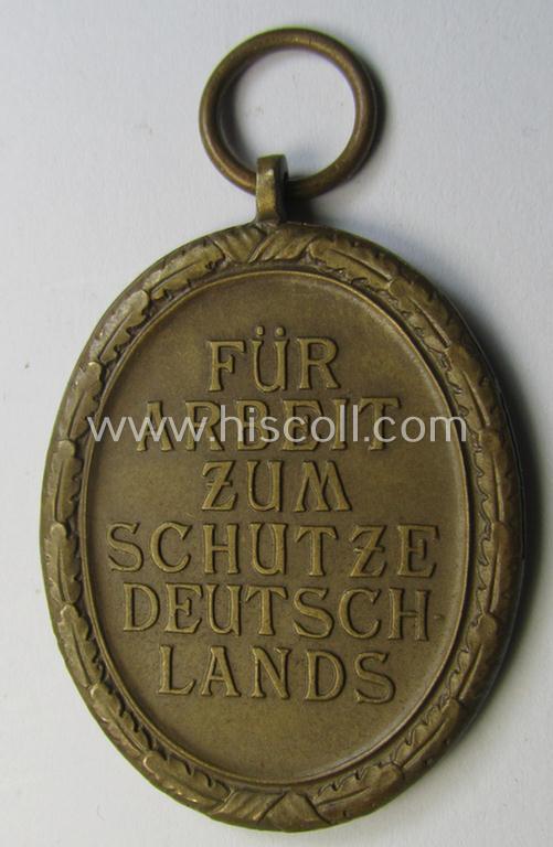 Medal-set: 'Deutsches Schutzwall Ehrenzeichen' (aka: 'Westwall'-medal) being a non-maker-marked- and/or: 'Buntmetall'-based specimen that comes together with its period- (and neatly folded ie. pre-confectioned) ribbon (ie. 'Bandabschnitt')
