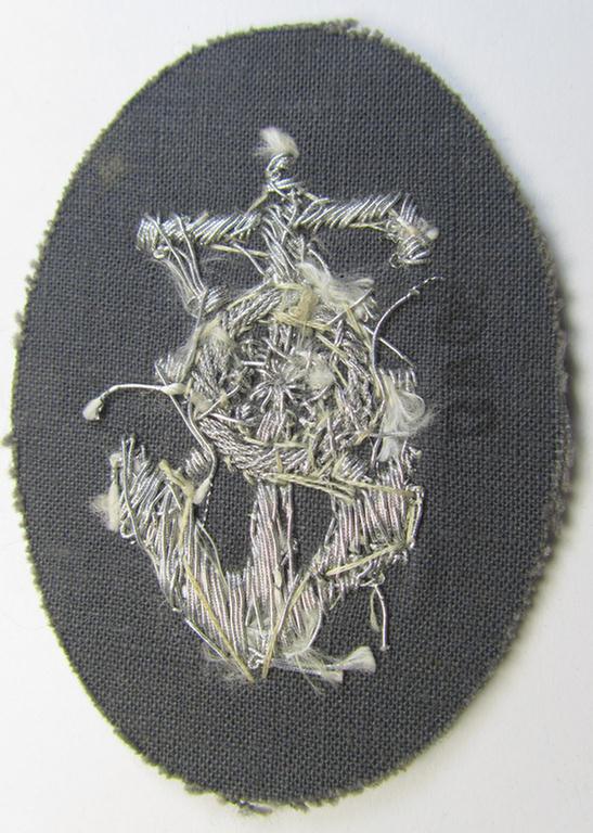 Neat, WH (Heeres) trade- and/or special-career insignia (being a detailed- and/or neatly hand-embroidered example as executed on field-grey-coloured wool as was intended for a: 'Steuermann' ie. enigineer-boat-pilot or helmsman)