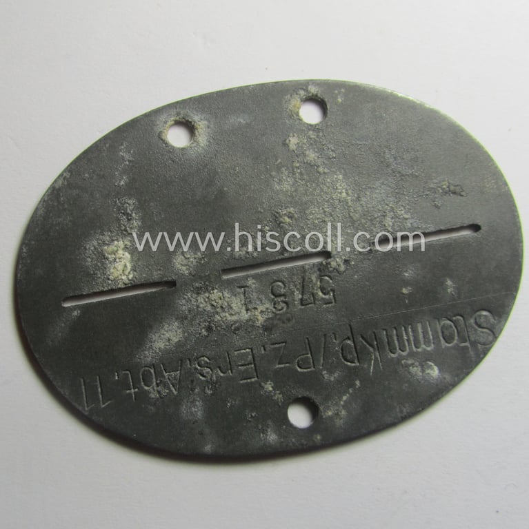 Zinc-based, WH (Heeres-) ie. 'Panzer'-related ID-disc (ie. 'Erkennungsmarke') bearing the clearly stamped unit-designation that reads: 'Stammkp./Pz.Ers.Abt.11' and that comes as issued and/or worn