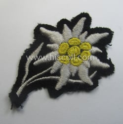 Waffen-SS-pattern, black-coloured M43-cap-insignia (ie. 'Mützenabzeichen') depicting an: 'Edelweiss'-flower...