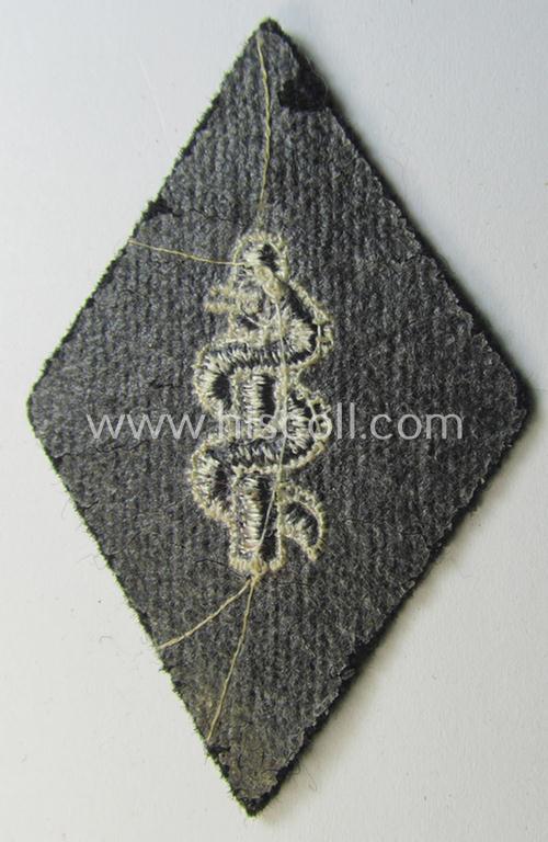 Waffen-SS-pattern, machine-embroidered and/or black- and white-coloured sleeve-insignia (ie. 'Ärmelraute') depicting a so-called: 'Aesculapus'-sign as was used and intended to signify membership within the 'SS-Sanitätsdienst'