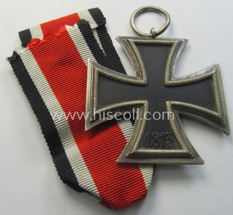 Moderately used, 'Eisernes Kreuz II. Klasse' being a non-maker-marked example that comes together with its original- and once-mounted ribbon (ie. 'Bandabschnitt') as was produced by a (by me) unidentified maker (ie. 'Hersteller')