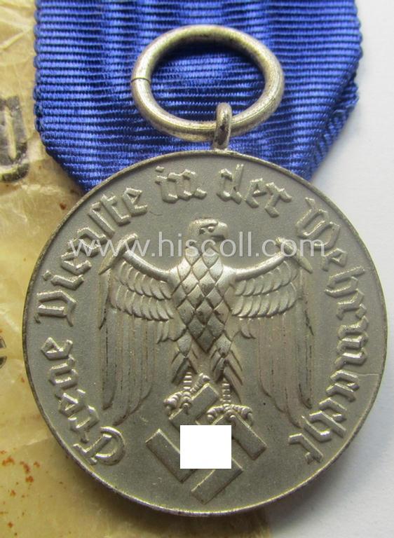 WH (Heeres o. KM) bright-silver-toned, 'WH-DA der 4. Klasse für 4 Jahre Dienstzeit' that comes with its accompanying ribbon (ie. 'Bandabschnitt') and eagle-device as stored in its period 'Cellophan'-based pouch
