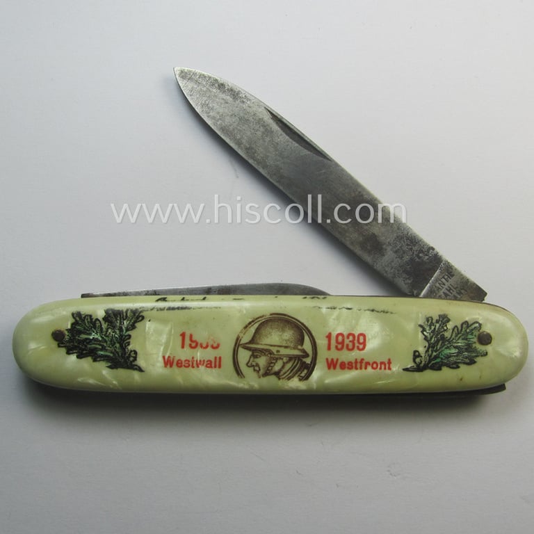 Interesting, (pre-) WWII-period 'souvenir-item' (ie. tiny pocket-knife) showing on its front an illustration of a soldier wearing a steel-helmet flanked by oakleaves coupled with the text: '1938 - 1939 - Westwall - Westfront'