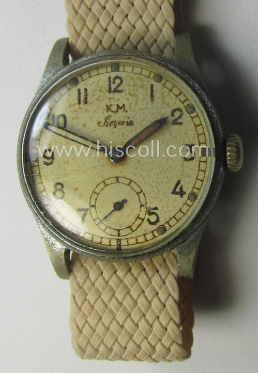 WH (Kriegsmarine) WWII-period wrist-watch (or: 'Dienstuhr') of the make: 'K.M. Siegerin' having a beige-white-coloured dial-plate and neatly engraved number on its back that reads: '120728'
