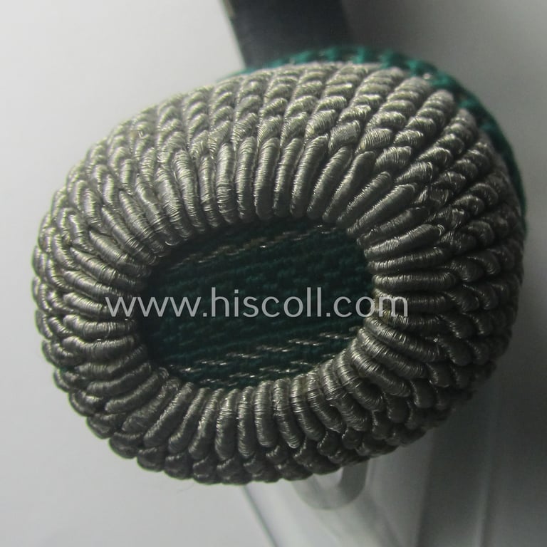 Bright-green- and silver-coloured, EM- (ie. NCO-) type side-arm knot (ie. 'Portepee' ie.: 'Troddel') as was used for the various WH-bayonets and that comes in an overall very nice- (ie. 'virtually mint- ie. unissued'-), condition