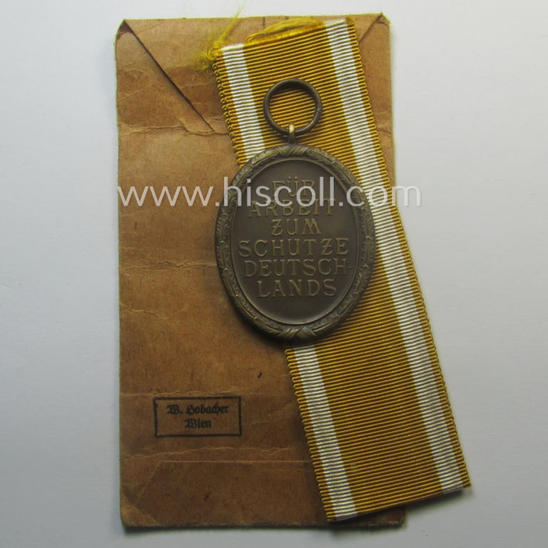 Medal-set: 'Deutsches Schutzwall Ehrenzeichen' (aka: 'Westwall'-medal) being a (typical) non-maker-marked- and/or: typical 'Buntmetall'-based specimen that comes packed in its original pouch of issue by the: 'Wilh. Hobacher'-company