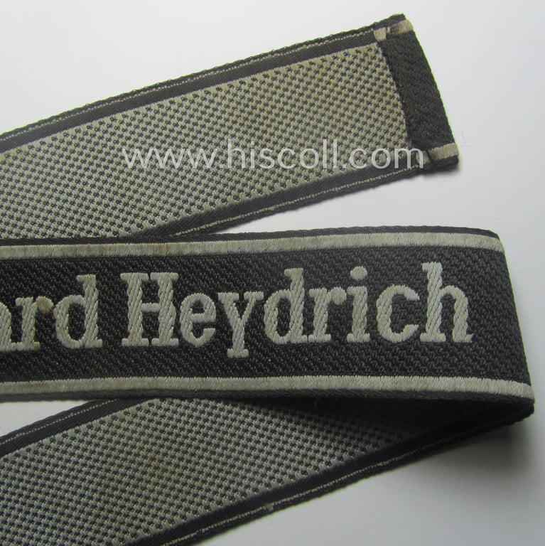Waffen-SS, 1943-pattern cuff-title (ie. 'Ärmelstreifen') depicting the machine-woven Latin script text in silver-grey linnen as was intended for a member of the: 'SS-Geb.Jäg.-Rgts. 6. (u.11.)': "Reinhard Heydrich"