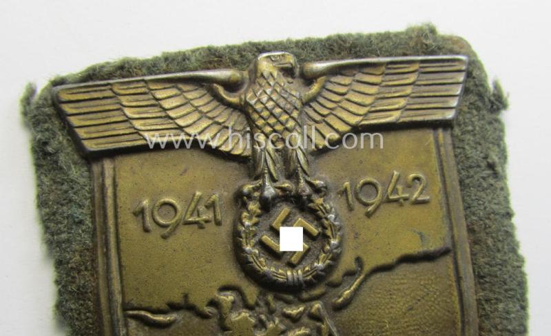 Truly worn, WH (Heeres o. Waffen-SS) 'Krim'-campaign-shield that comes mounted onto its original, field-grey-coloured 'backing' and that comes in a surely issued-, worn and/or carefully tunic-removed-, condition