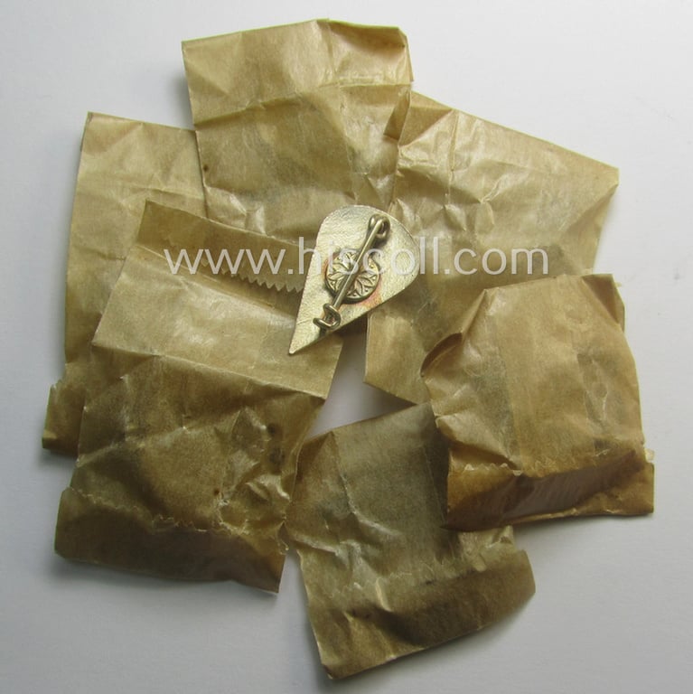 Neatly enamelled, WH (Luftwaffe) so-called: 'Truppen-Traditionsabzeichen des 1. Fallschirm-Korps' that comes stored in its period, 'Cellophan'-based pouch by the (Italian) maker: 'G. Bregonzio - Milano'